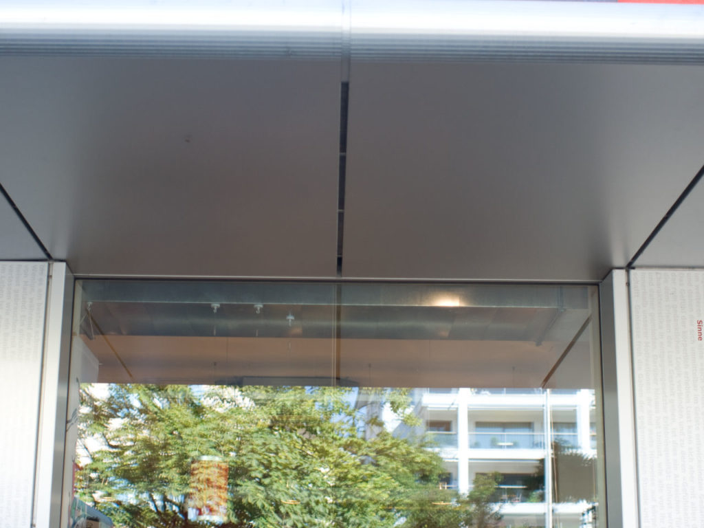 Vordach aus Aluminiumkassetten und Schaufenster
